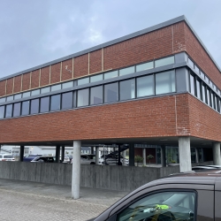Inddækning med aluminium på tagkant af moderne erhvervsbygning med røde mursten i Odense