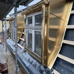 To messingbeklædte kviste med integrerede tagrender og nedløb – eksklusivt blikarbejde på tag i Odense.